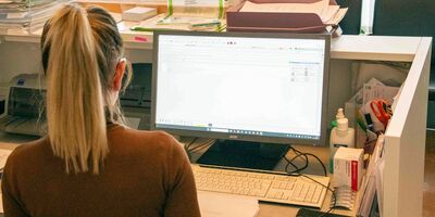 Empfang Praxis - Frau am PC